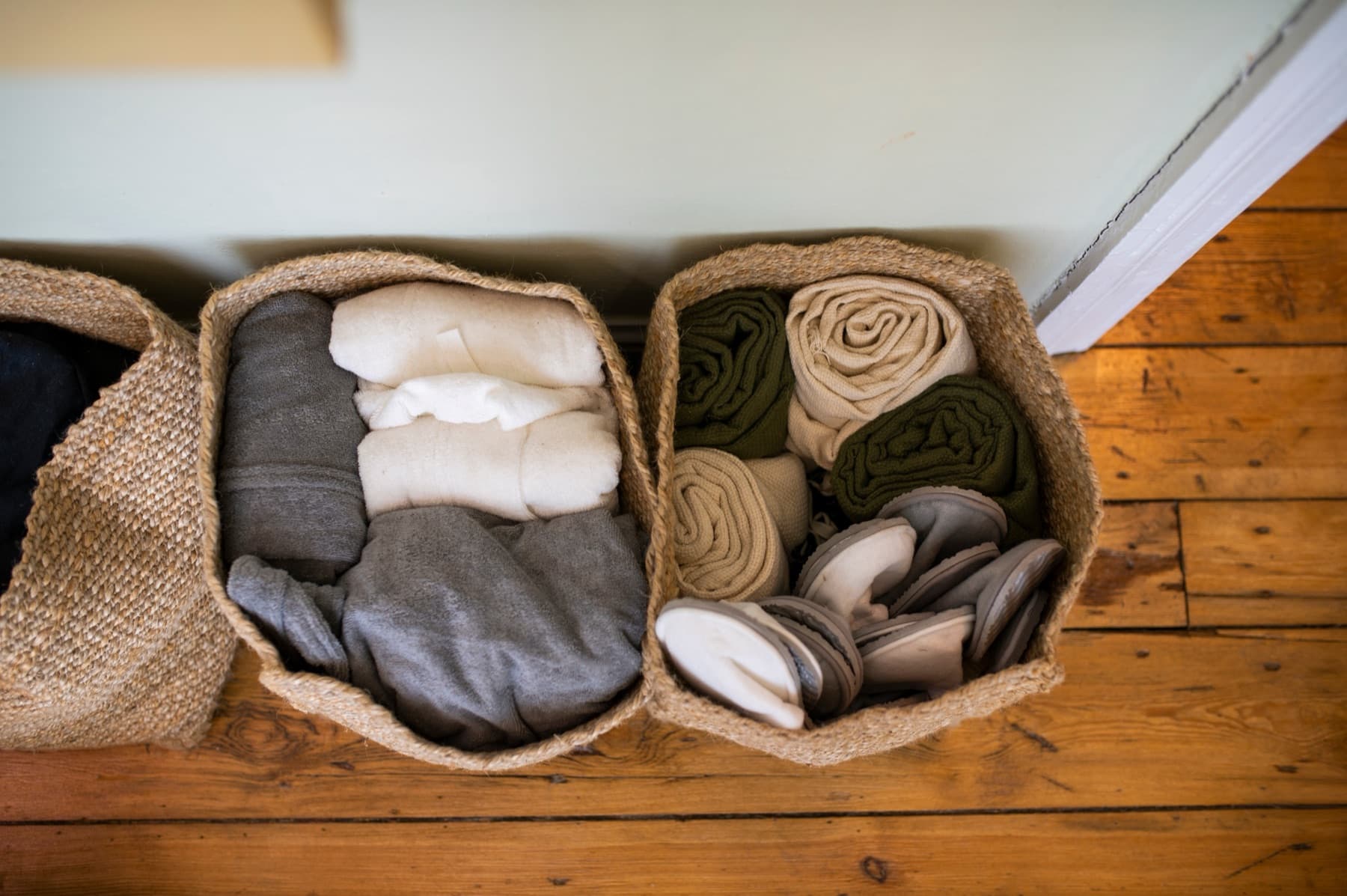 Folded linen and towels sorted into woven baskets