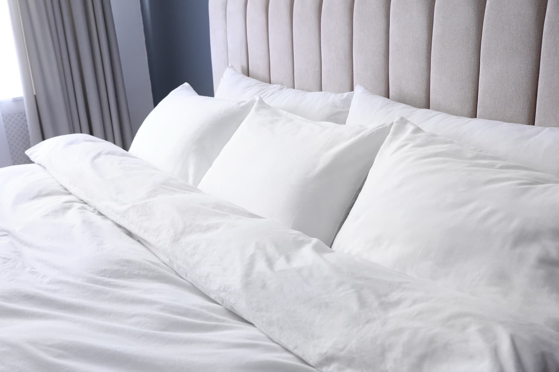 Freshly made bed with crisp white sheets and pillows