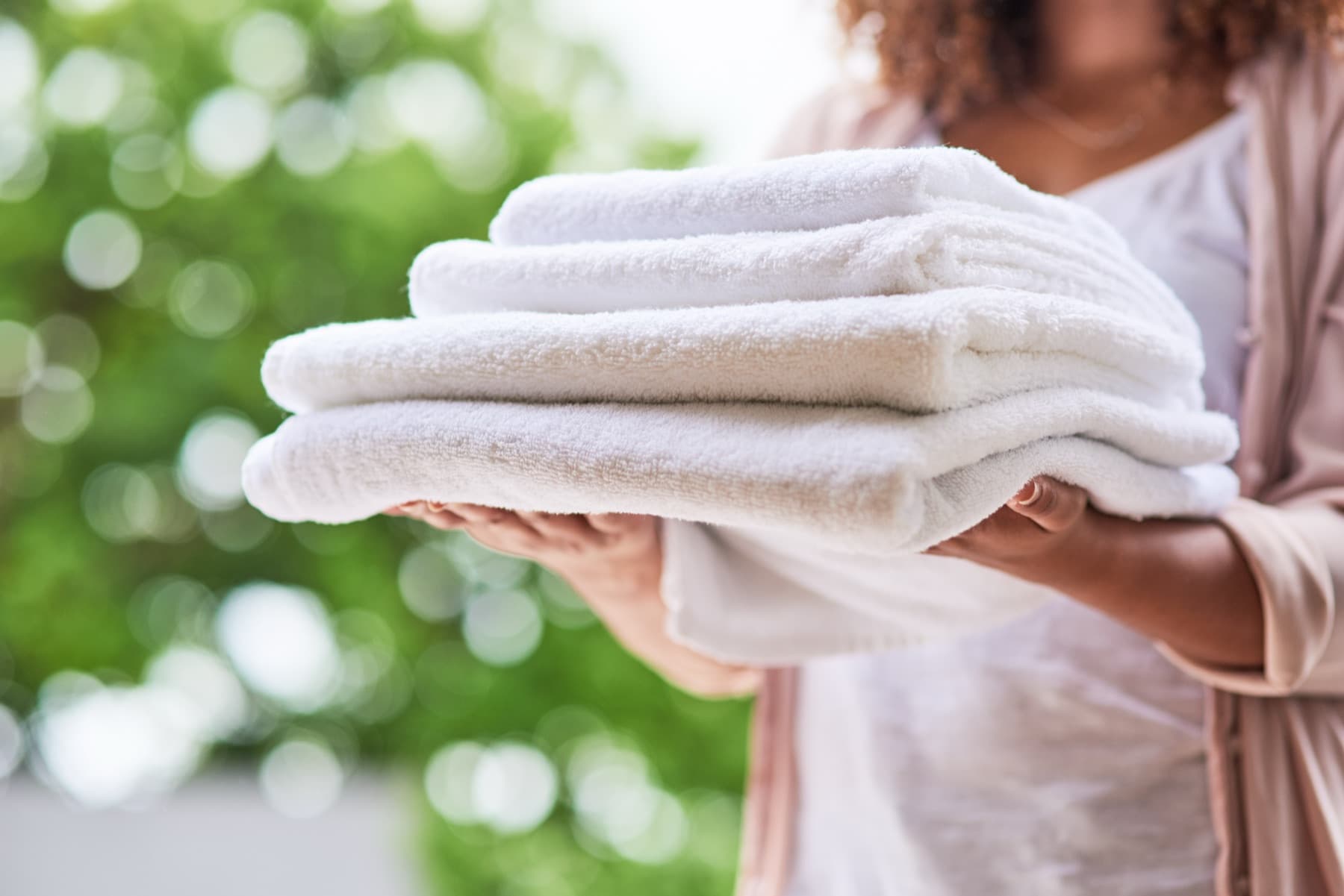 Folded white towels held in two hands